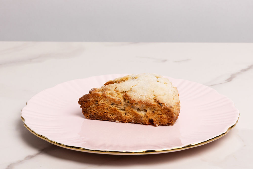 A sugared scone on a pink scalloped plate at Sage